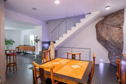une salle à manger avec une table et des chaises et un escalier dans l'établissement L'EMPEREUR somptueux duplex au style raffiné, Petit Juas, proche du centre, à Cannes