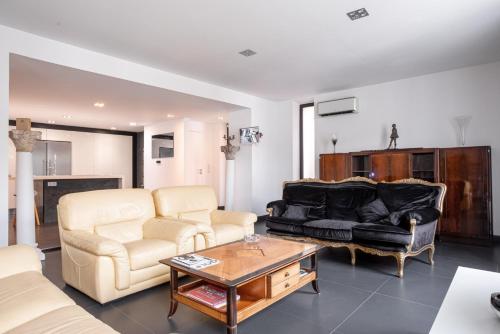 un salon avec un canapé et une table dans l'établissement L'EMPEREUR somptueux duplex au style raffiné, Petit Juas, proche du centre, à Cannes