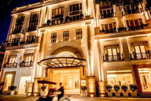 - un grand bâtiment blanc avec une arche en face dans l'établissement Apricot Hotel, à Hanoï