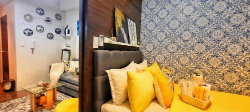 Stylish&Comfort Unit in Air Makati by Luca's Cove في مانيلا: غرفة معيشة مع أريكة مع وسائد صفراء