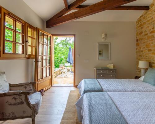 une chambre avec un lit et une chaise dans une pièce dans l'établissement La Bergerie, à Mauzac-et-Grand-Castang