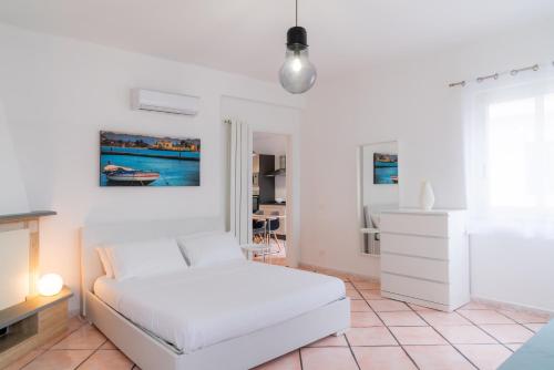 een witte slaapkamer met een bed en een tafel bij MONDELLO COTTAGE in Mondello