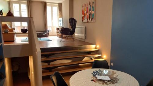 sala de estar con mesa y sillas y escalera en Burdigala Homes - Appart du Jardin Public, en Burdeos