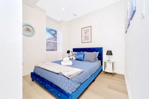 a bedroom with a blue bed in a white room at 2BR Apartment in James Street in Hamilton