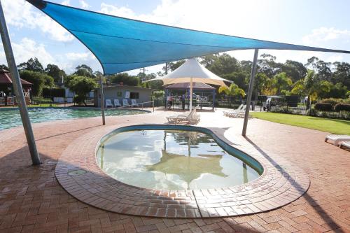 a large blue umbrella over a swimming pool at Discovery Parks - Eden in Eden