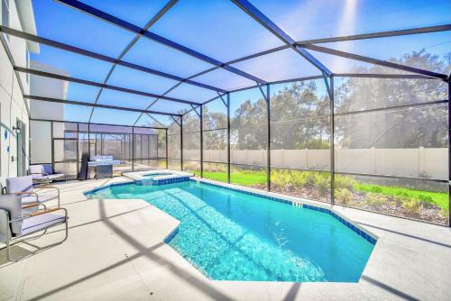 a swimming pool in a house with a glass extension at 10BR Resort Home - Pool Hot tub Games - Near Disney in Kissimmee
