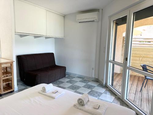 a room with a bed and a couch and a window at Résidence Aigue Marine in Coti-Chiavari