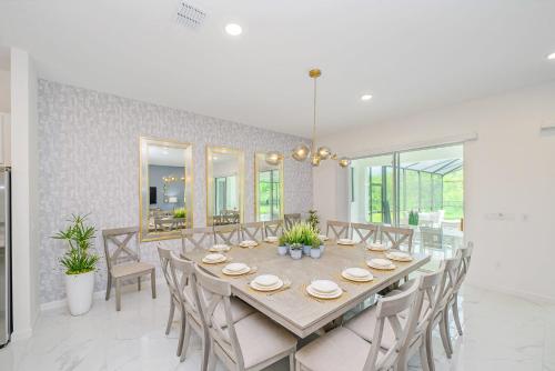 a dining room with a long table and chairs at Near Disney - 12BR Home - Private Pool and Hot Tub in Kissimmee