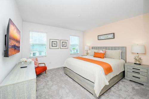 a white bedroom with a bed and a chair at Near Disney - 12BR Home - Private Pool and Hot Tub in Kissimmee