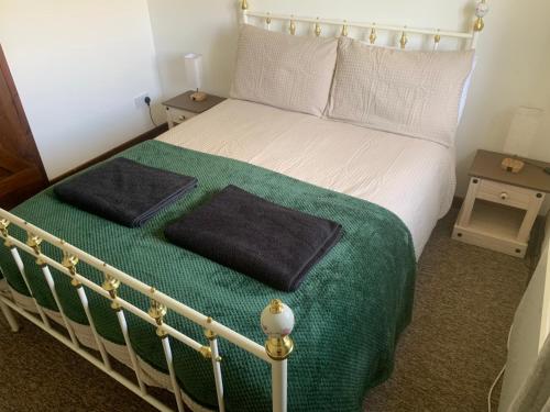um quarto com uma cama com duas almofadas em Mandarin Cottage- quirky upside down retreat - Norfolk em Mileham