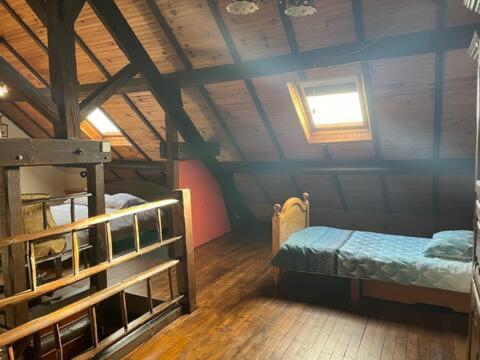Camera mansardata con letto e finestra. di Appartement rustique, type chalet a Méhoncourt