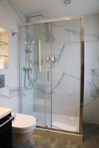 a bathroom with a glass shower with a toilet at Rove Hotel London Paddington in London