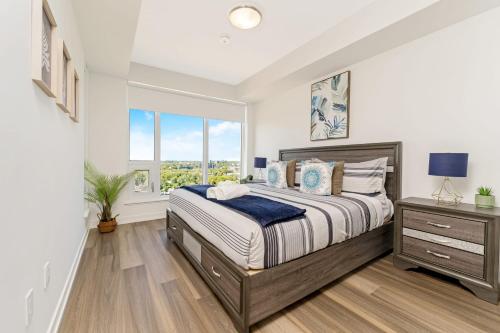 a bedroom with a large bed and a window at Modern 1BR King Bed Condo - Private Balcony in Kitchener