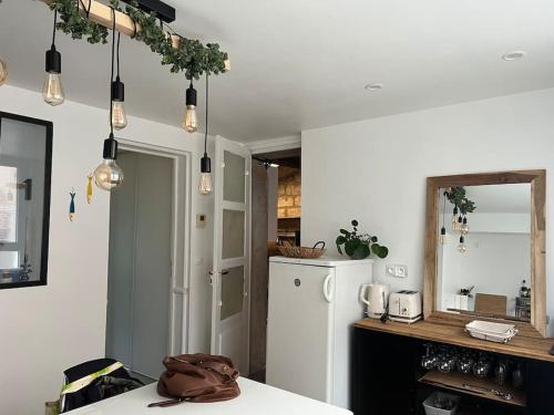 La cuisine est équipée d'un réfrigérateur blanc et d'un miroir. dans l'établissement Un break à Mers ?, à Mers-les-Bains