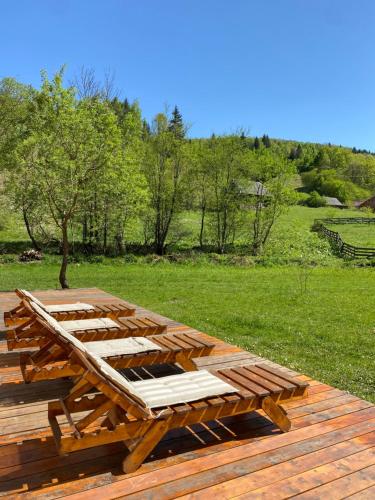 a wooden picnic table on top of a wooden deck at Scrind 11 - Madleine Chalet in Cluj-Napoca