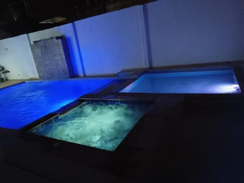 duas piscinas com água azul num quarto em Vivienda Turística el Refugio em Villavicencio