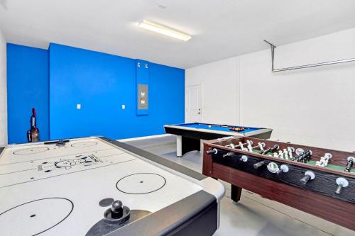 two pool tables in a room with blue walls at Modern 6BR Home - Pool BBQ Hot Tub - Near Disney in Kissimmee