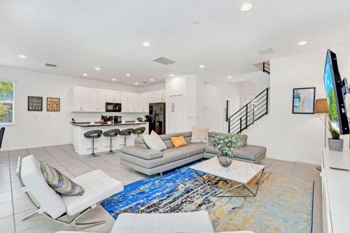 a living room with a couch and a table at Modern 6BR Home - Pool BBQ Hot Tub - Near Disney in Kissimmee
