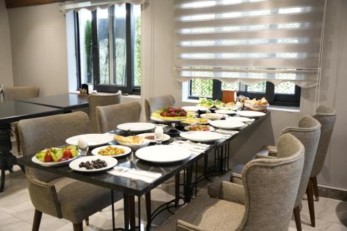 una sala da pranzo con tavolo pieno di cibo di Eniza Hotel a Mersin