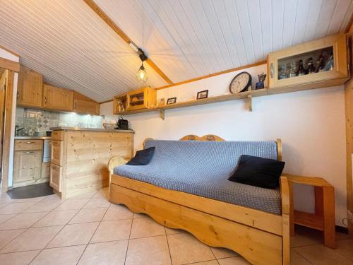 - une chambre avec un lit en bois dans une cuisine dans l'établissement Appartement Chaleureux avec Balcons au Coeur de Samoëns, Proche Ski-Bus - FR-1-624-147, à Samoëns