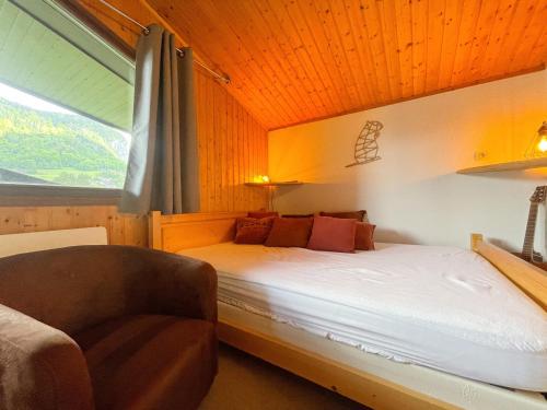 une chambre avec un lit, une fenêtre et une chaise dans l'établissement Appartement Chaleureux avec Balcons au Coeur de Samoëns, Proche Ski-Bus - FR-1-624-147, à Samoëns