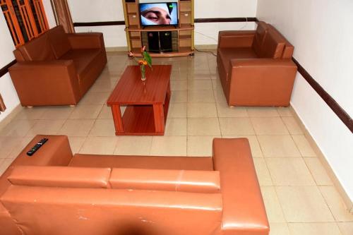 a living room with a couch and a tv at Covenant Park Inn Guest House in Huye