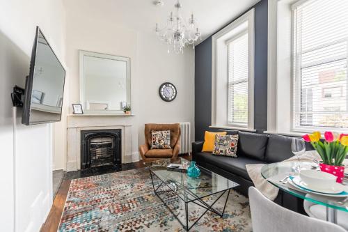a living room with a black couch and a fireplace at Apartment in the James South Neighborhood in Hamilton