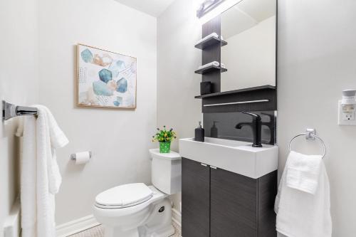 a bathroom with a white toilet and a sink at Apartment in the James South Neighborhood in Hamilton