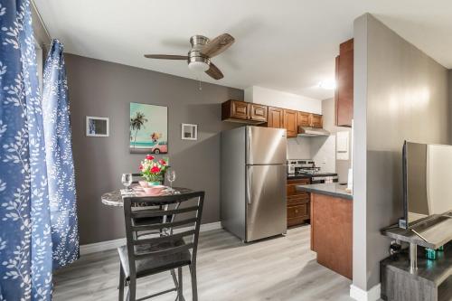 漢密爾頓的住宿－Glenview West Apartment w Patio - Near Downtown，厨房配有桌子和不锈钢冰箱。