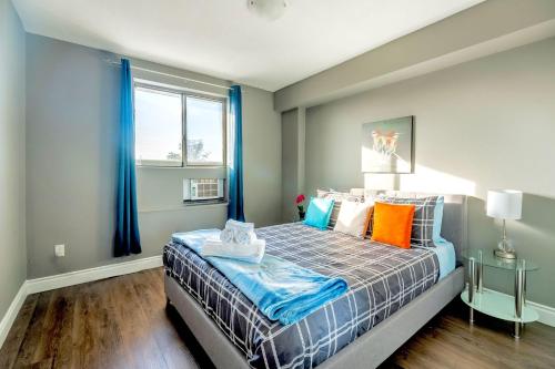 漢密爾頓的住宿－Glenview West Apartment w Patio - Near Downtown，一间卧室配有一张带蓝色窗帘的床和一扇窗户