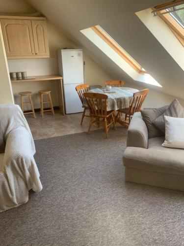 uma cozinha e sala de jantar com uma mesa e um sofá em Mandarin Cottage- quirky upside down retreat - Norfolk em Mileham