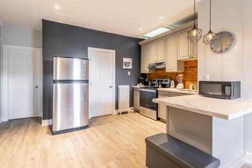 a large kitchen with a stainless steel refrigerator at Hamilton's Best Neighbourhood 1BR Apartment in Hamilton
