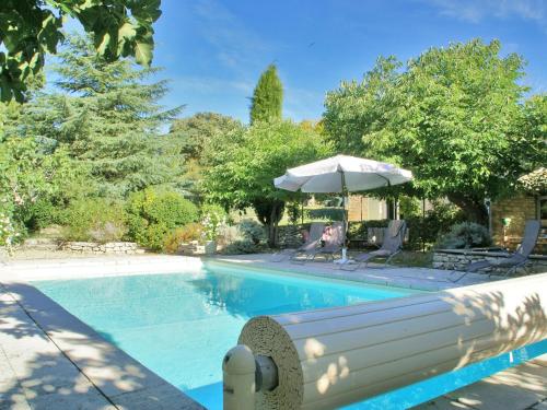 ViensにあるSplendid Villa in Viens with Swimming Poolのパラソルと椅子付きのスイミングプール