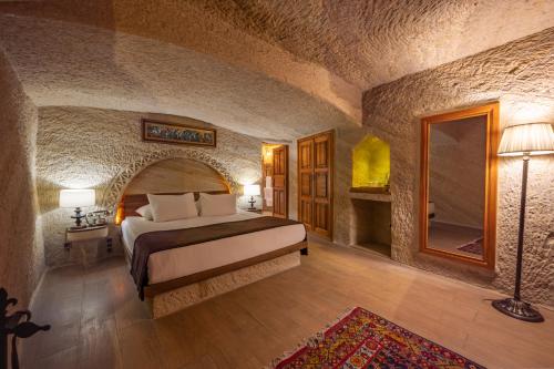 a bedroom with a bed in a stone room at Utopia Cave Cappadocia in Urgup