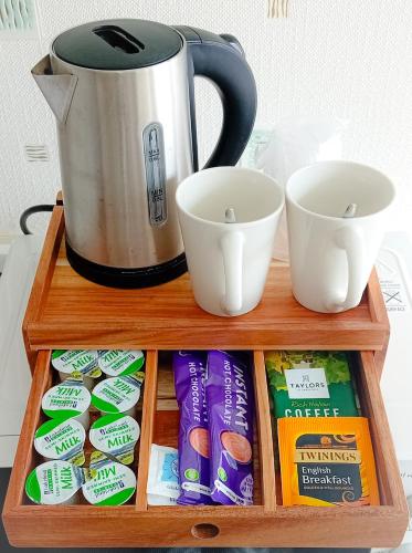 a wooden tray with a coffee pot and cups at Home and Away near the Spa in Bridlington