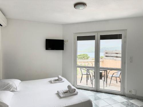 een slaapkamer met een bed en een balkon met uitzicht bij Résidence Aigue Marine in Coti-Chiavari