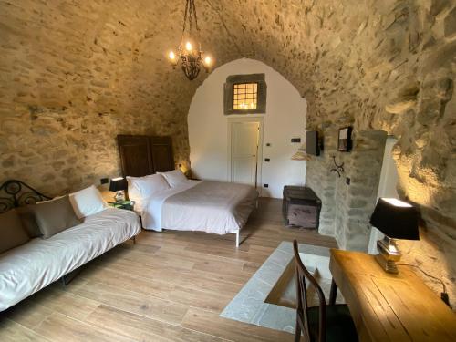 a bedroom with a bed and a couch in a room at La Casa Medievale Suites e SPA in Pontremoli