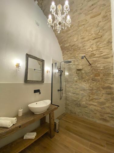 a bathroom with a sink and a stone wall at La Casa Medievale Suites e SPA in Pontremoli