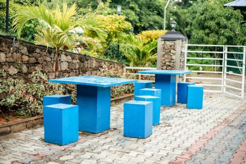 two blue tables and stools on a brick patio at Capital Resort Inn in Monaragala