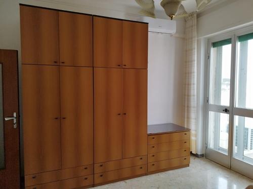 a large wooden cabinet in a room with a window at La Casa del Corso in Alberobello