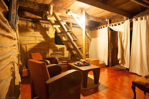 a living room with a spiral staircase in a log cabin at Iharana Bush Camp in Ambondromifehy