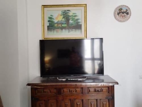 a flat screen tv sitting on top of a wooden cabinet at La Casa del Corso in Alberobello