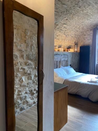 a bedroom with a bed and a stone wall at La Casa Medievale Suites e SPA in Pontremoli