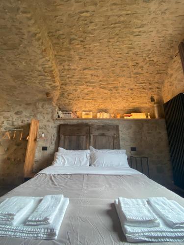 a bedroom with a bed in a stone wall at La Casa Medievale Suites e SPA in Pontremoli