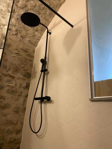 a shower with a shower head on a wall at La Casa Medievale Suites e SPA in Pontremoli