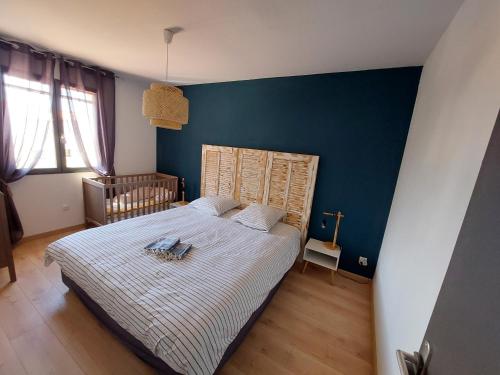 a bedroom with a bed with a blue wall at Villa CALLY, chez MARIUS in Vidauban