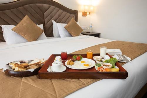 a tray with breakfast foods on a bed at Grand Hotel Kathmandu in Kathmandu