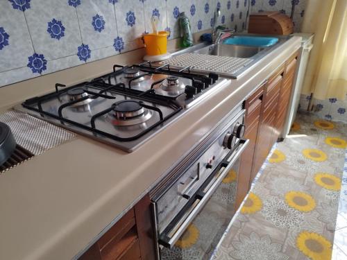 a stove top in a kitchen with a sink at La Casa del Corso in Alberobello