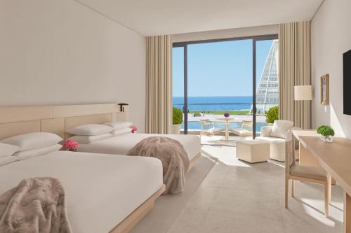 sypialnia z 2 łóżkami i widokiem na ocean w obiekcie The Jeddah EDITION w mieście Dżudda