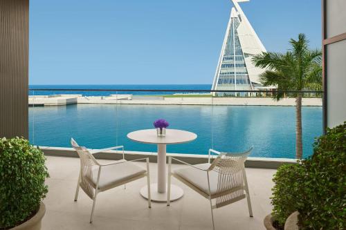 a table and chairs with a view of the ocean at The Jeddah EDITION in Jeddah